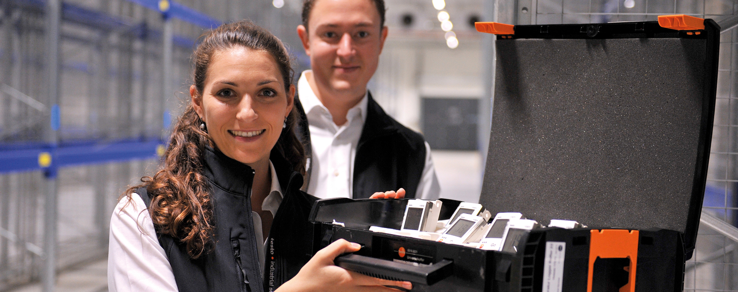 professional climate distribution measurements Employees of Testo Industrial Services stand in a high-bay warehouse with a case full of data loggers and prepare a mapping